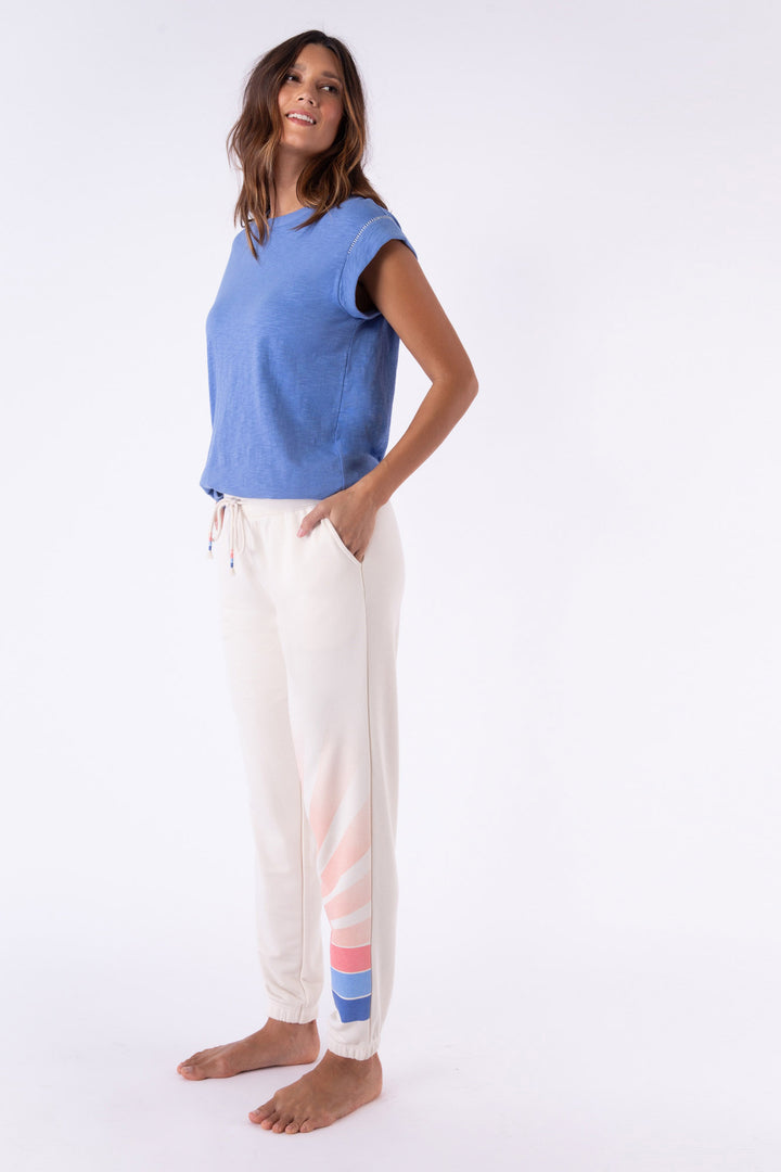 Ivory French Terry jogger pant with striped sunrise printed on left leg. Side pockets.