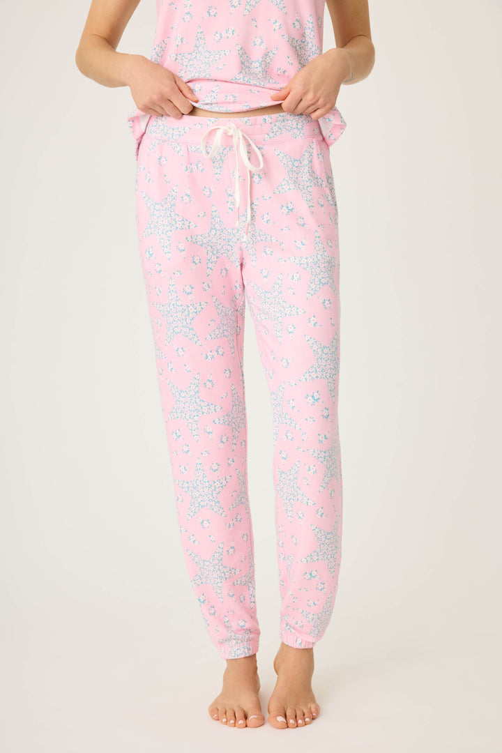 Women's pink & star print jogger pant with pockets in peachy jersey. Tie waist & banded hem. Scallop edge trim at pocket openings.