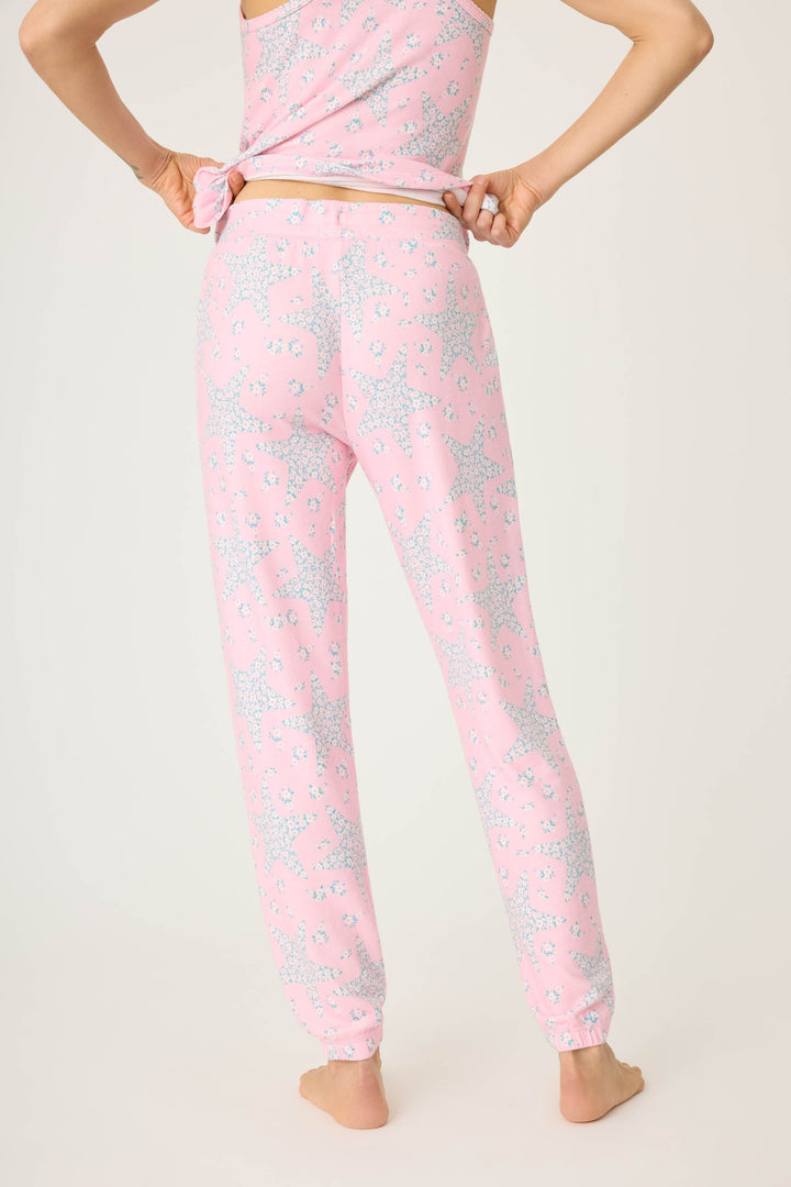 Women's pink & star print jogger pant with pockets in peachy jersey. Tie waist & banded hem. Scallop edge trim at pocket openings.