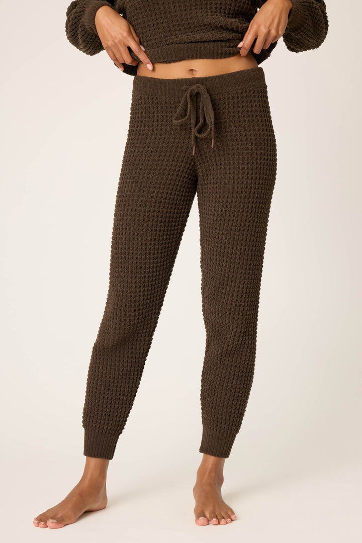 A person wearing P.J. Salvage's Chenille Waffle Solid Chocolate Banded Pant stands barefoot against a plain light background, with their torso and head partially out of frame.