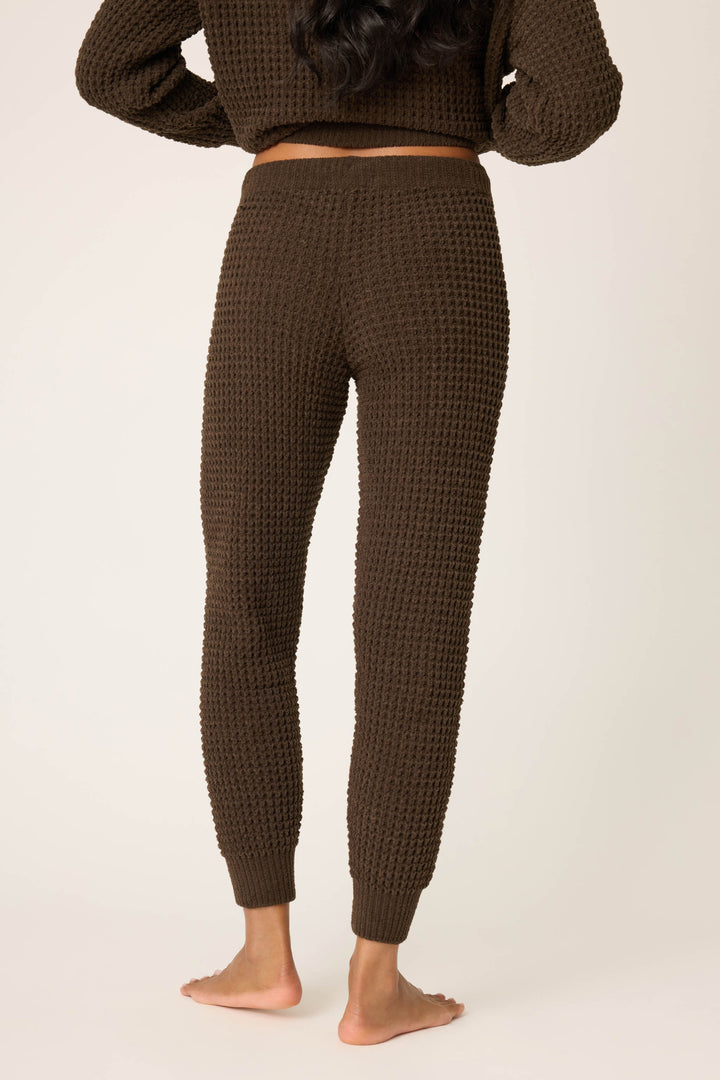A person stands barefoot on a light surface, showing the back view from shoulders to feet, wearing P.J. Salvage's Chenille Waffle Solid Chocolate Banded Pant with a matching top.