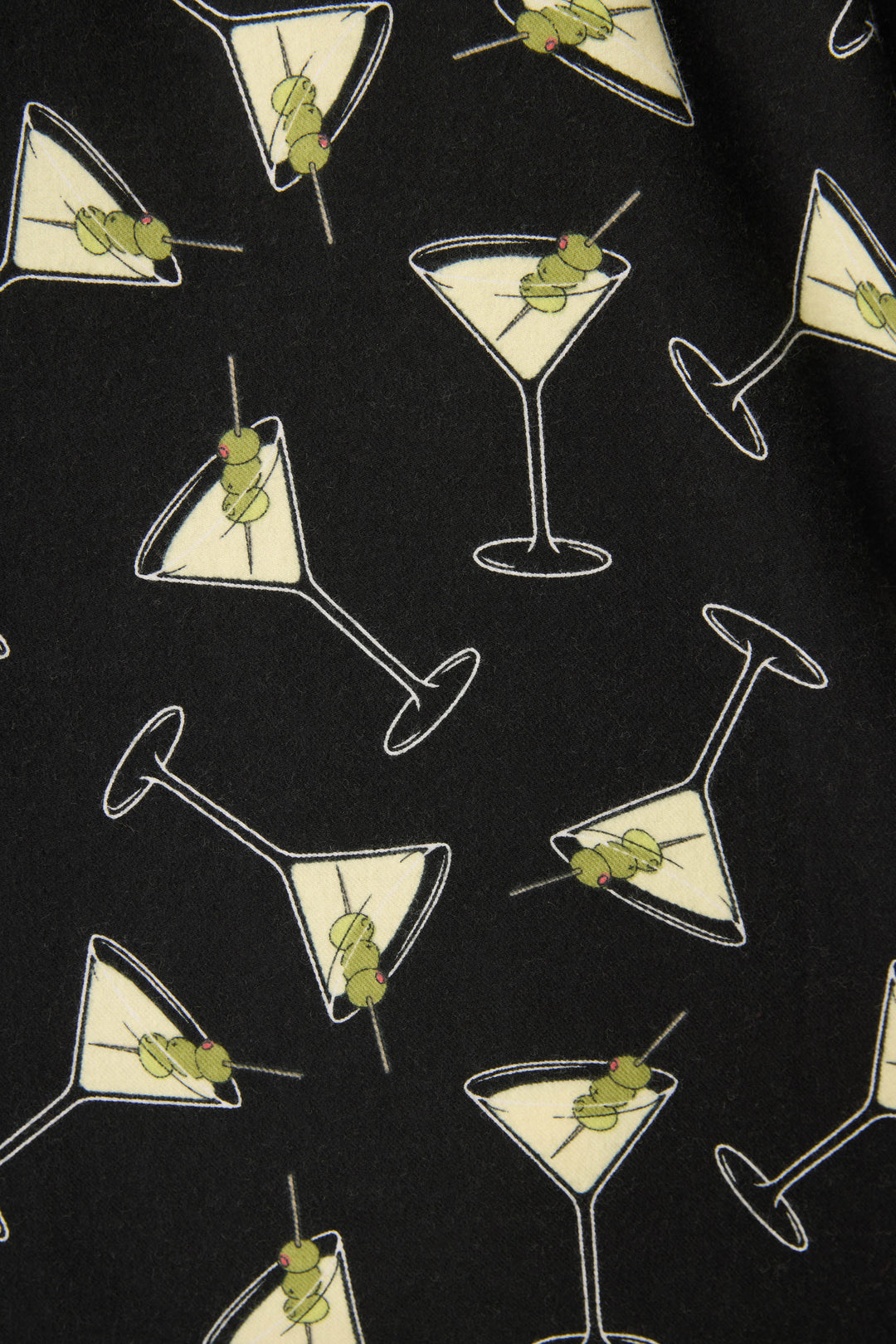 The Merrier With A Martini Flannel Plus Size PJ Set by P.J. Salvage features black fabric with a playful print of martini glasses filled with pale yellow liquid and green olive garnishes on toothpicks.