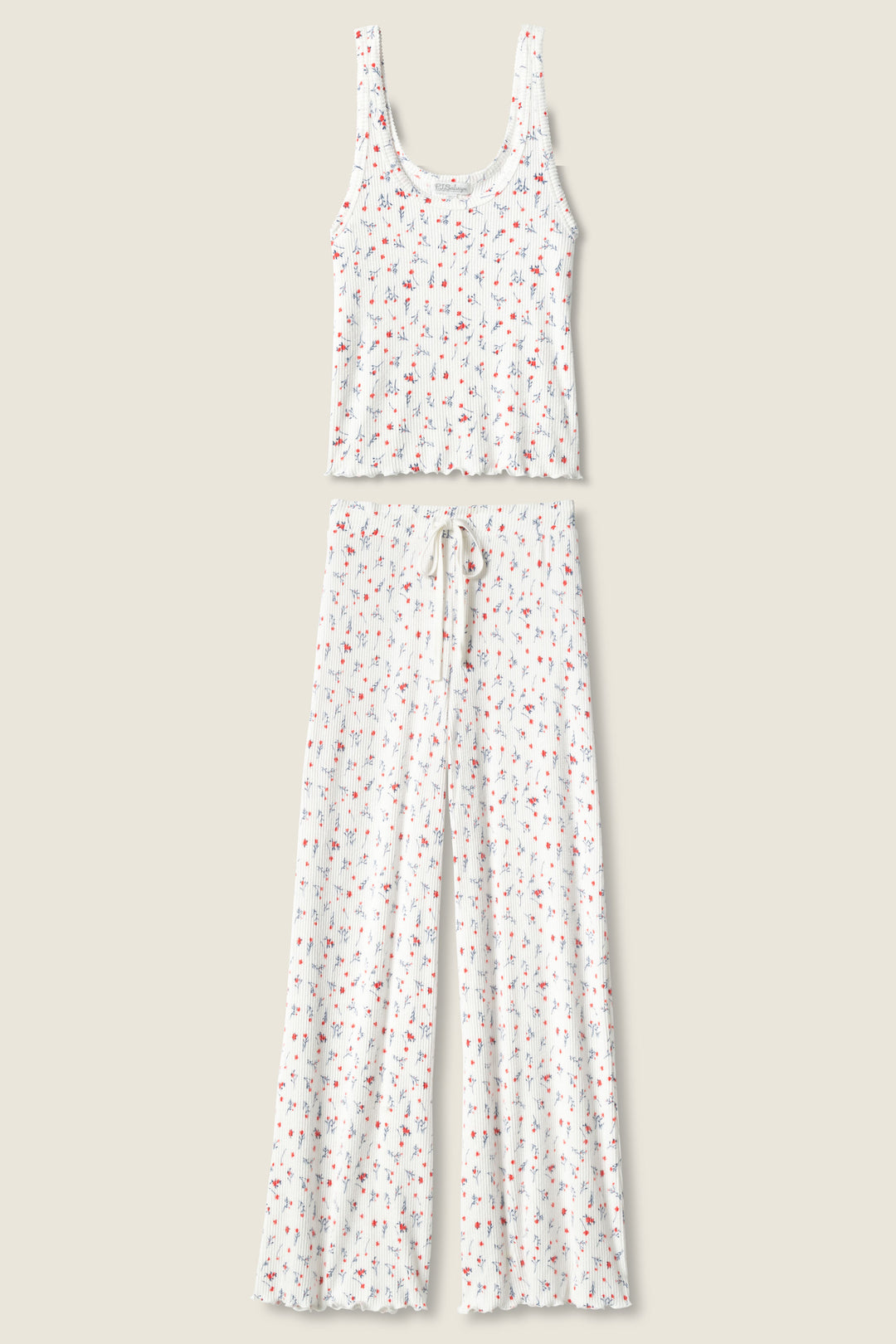 The FLORAL PJ SET LA ROSE by P.J. Salvage features a white tank top and wide-leg pants with a small, colorful floral print and drawstring waist, shown laid flat on a beige background.