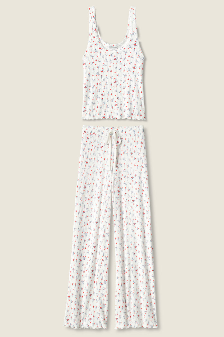 The FLORAL PJ SET LA ROSE by P.J. Salvage features a white tank top and wide-leg pants with a small, colorful floral print and drawstring waist, shown laid flat on a beige background.