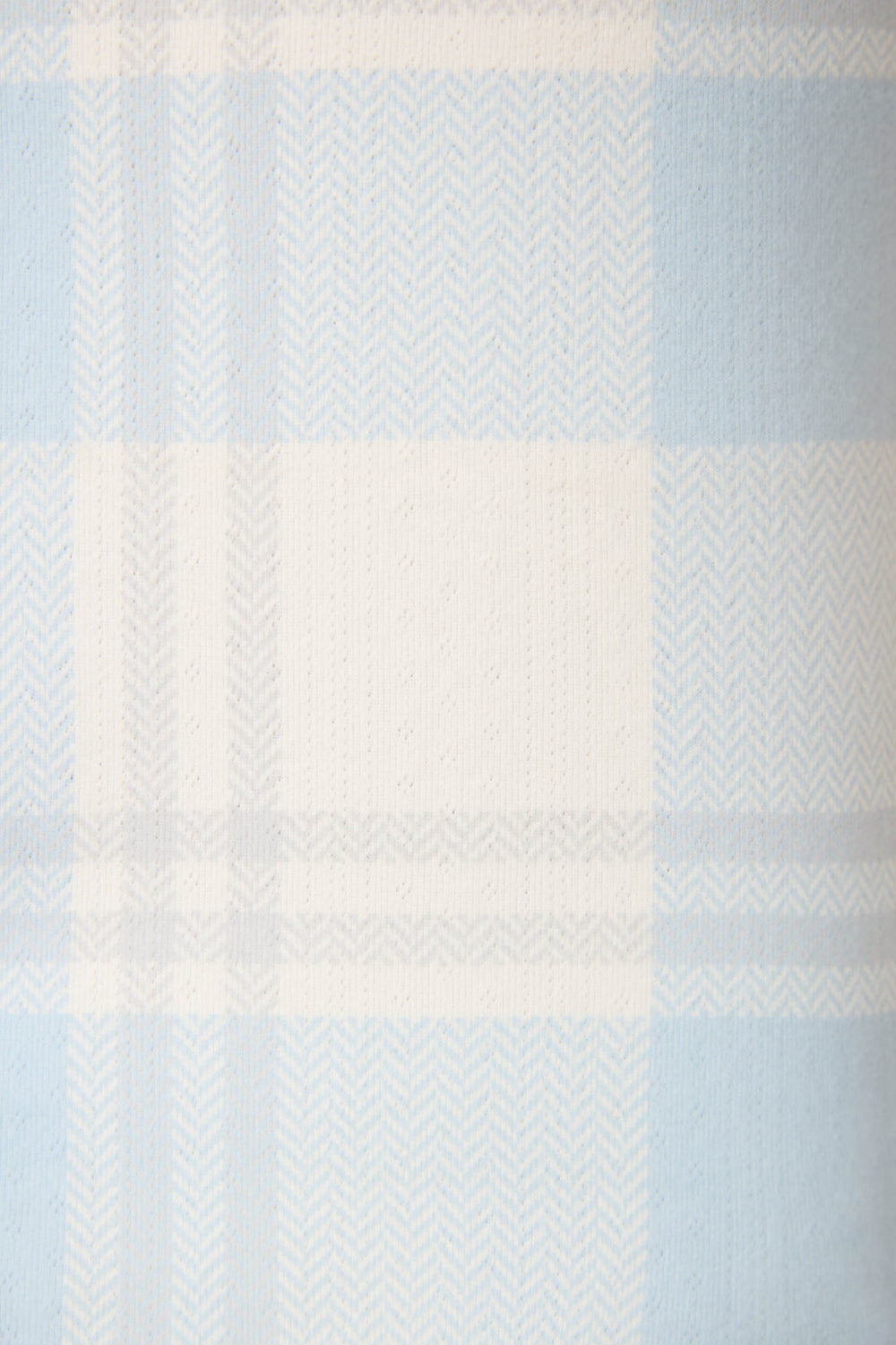 A close-up of the Pointelle Essentials Plaid 4-Piece Loungewear Set by P.J. Salvage, showcasing its light blue and white plaid fabric with horizontal and vertical stripes and a herringbone texture.