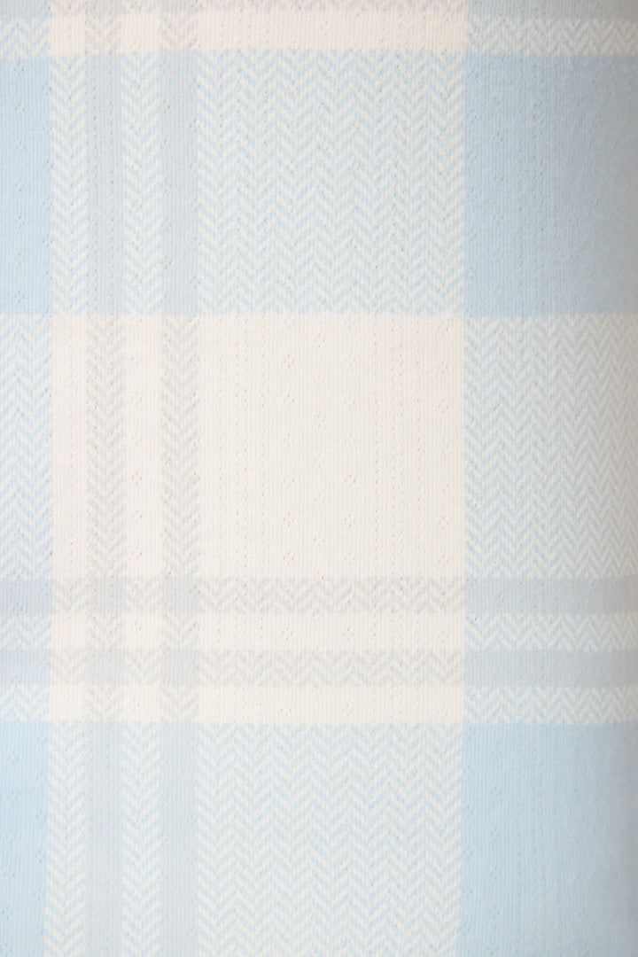 A close-up of the Pointelle Essentials Plaid 4-Piece Loungewear Set by P.J. Salvage, showcasing its light blue and white plaid fabric with horizontal and vertical stripes and a herringbone texture.