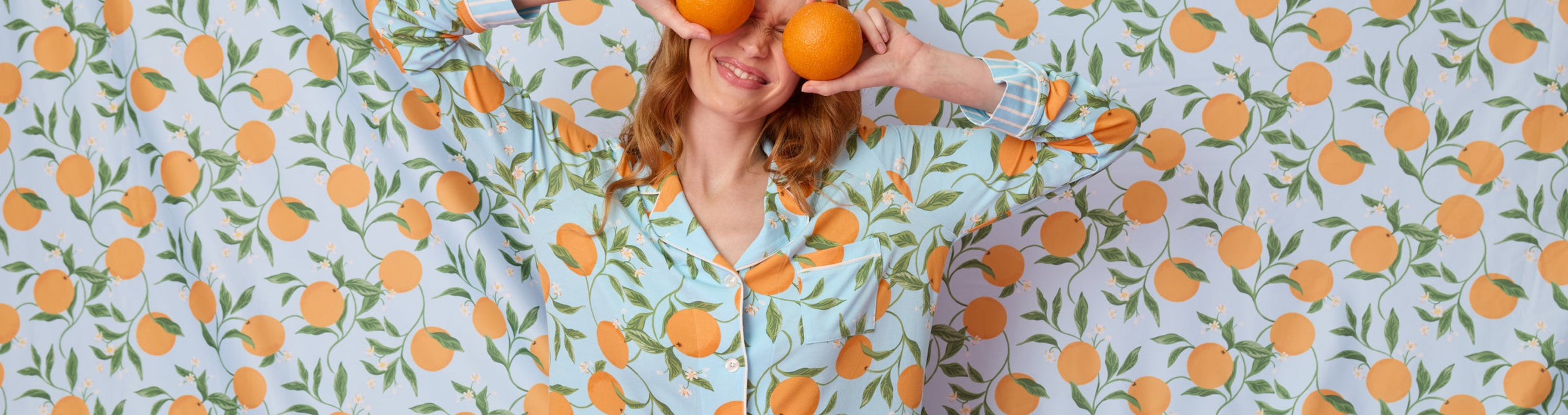 Three women wearing different styles of pajamas pose against a light background. One wears black, one wears a patterned set, and one wears gray pajamas with a matching sleep mask, all expressing relaxed or sleepy moods.