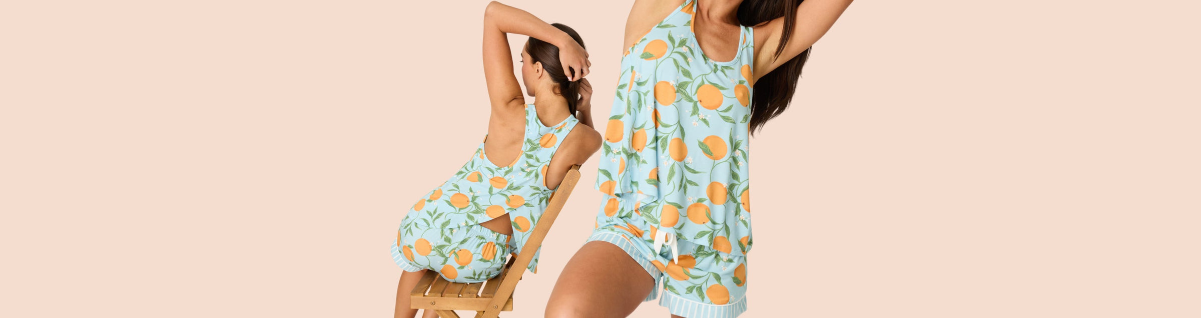 A woman wearing a matching grey and white animal print sweatshirt and shorts poses playfully in a studio with a desert landscape backdrop, smiling and sitting on the floor and a stool.