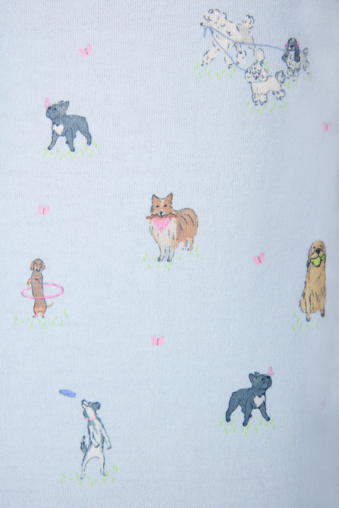 The Bark Park Fetch & Frolic fabric is a light blue fabric with hand-drawn dogs and pink butterflies scattered over a grassy background—ideal for any dog lover’s pajama collection.