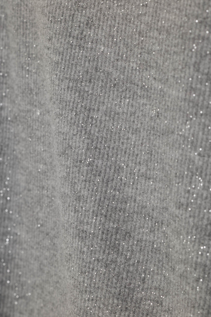 Close-up of a gray knit fabric with fine silver glitter throughout, showing the texture and shimmer.