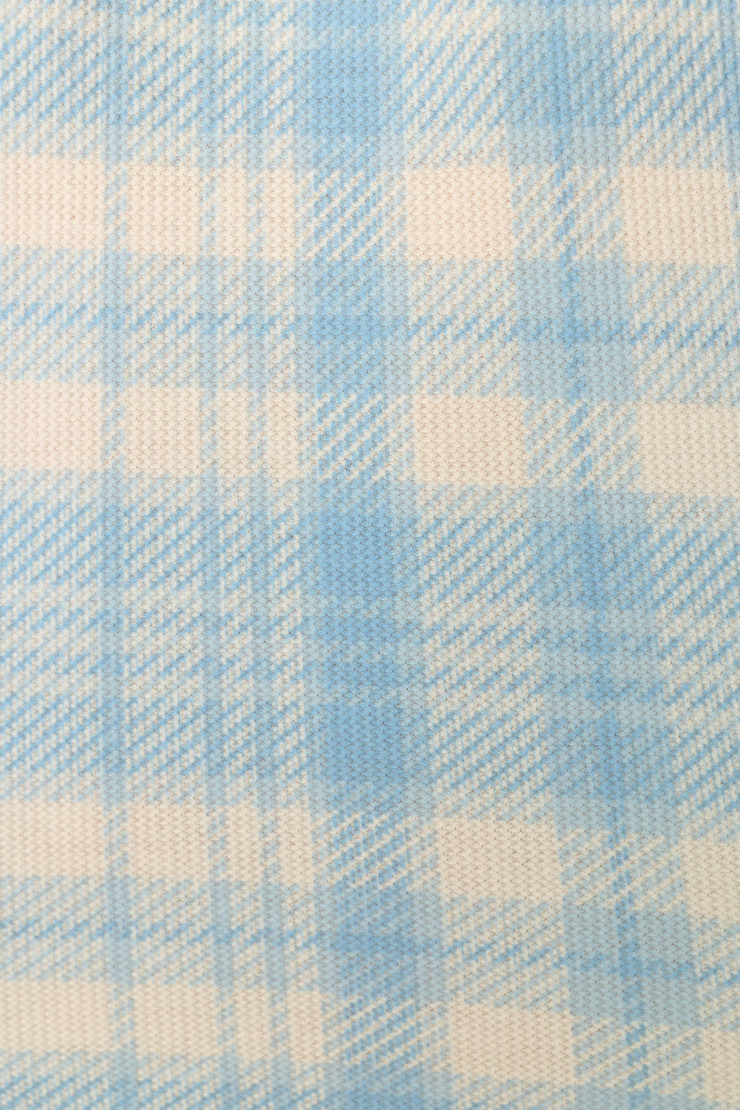 A close-up of a light blue and off-white plaid fabric pattern with a visible woven texture.