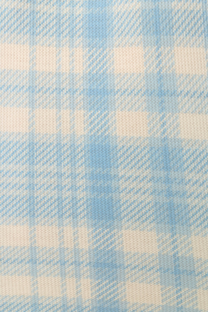 A close-up of a light blue and off-white plaid fabric pattern with a visible woven texture.