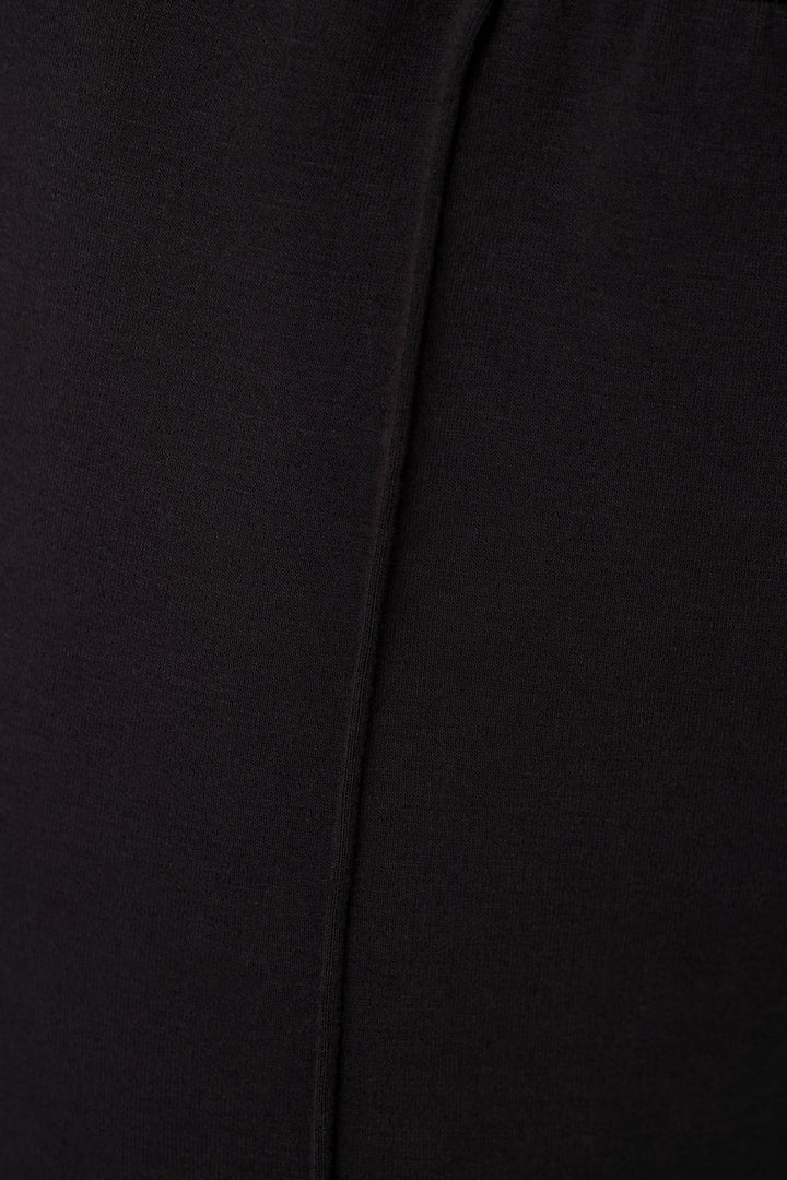 Close-up of a black fabric surface with a vertical seam or fold running down the center.