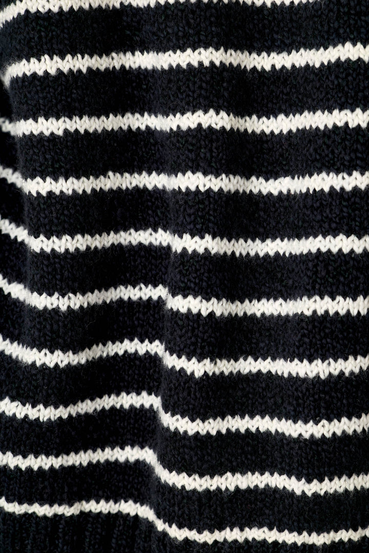 Close-up of a knitted fabric with horizontal black and white stripes.