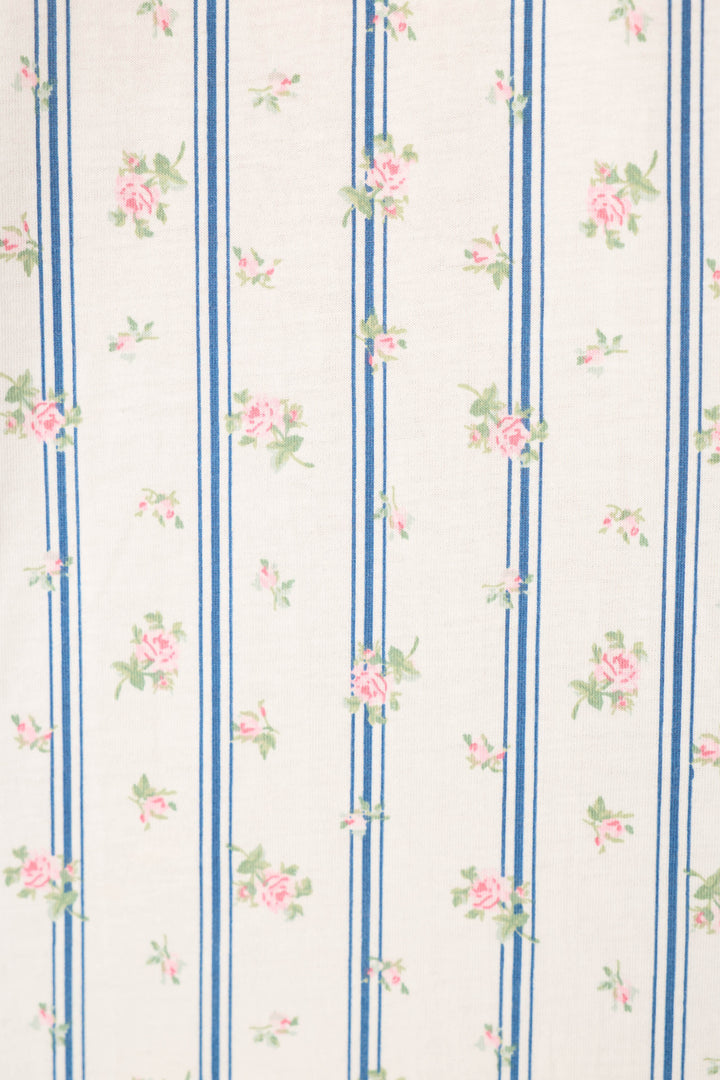 The P.J. Salvage Cotton Jersey Stripes & Blooms Cropped PJ Set features white fabric with vertical blue stripes and a repeating floral pattern of small pink roses and green leaves for a vintage, delicate look.