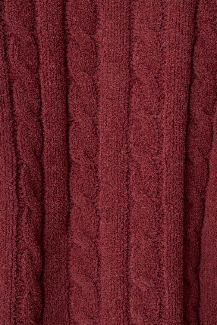 A close-up of a dark win, maroon colored cable-knit fabric texture, showing the detailed knit pattern and soft folds.