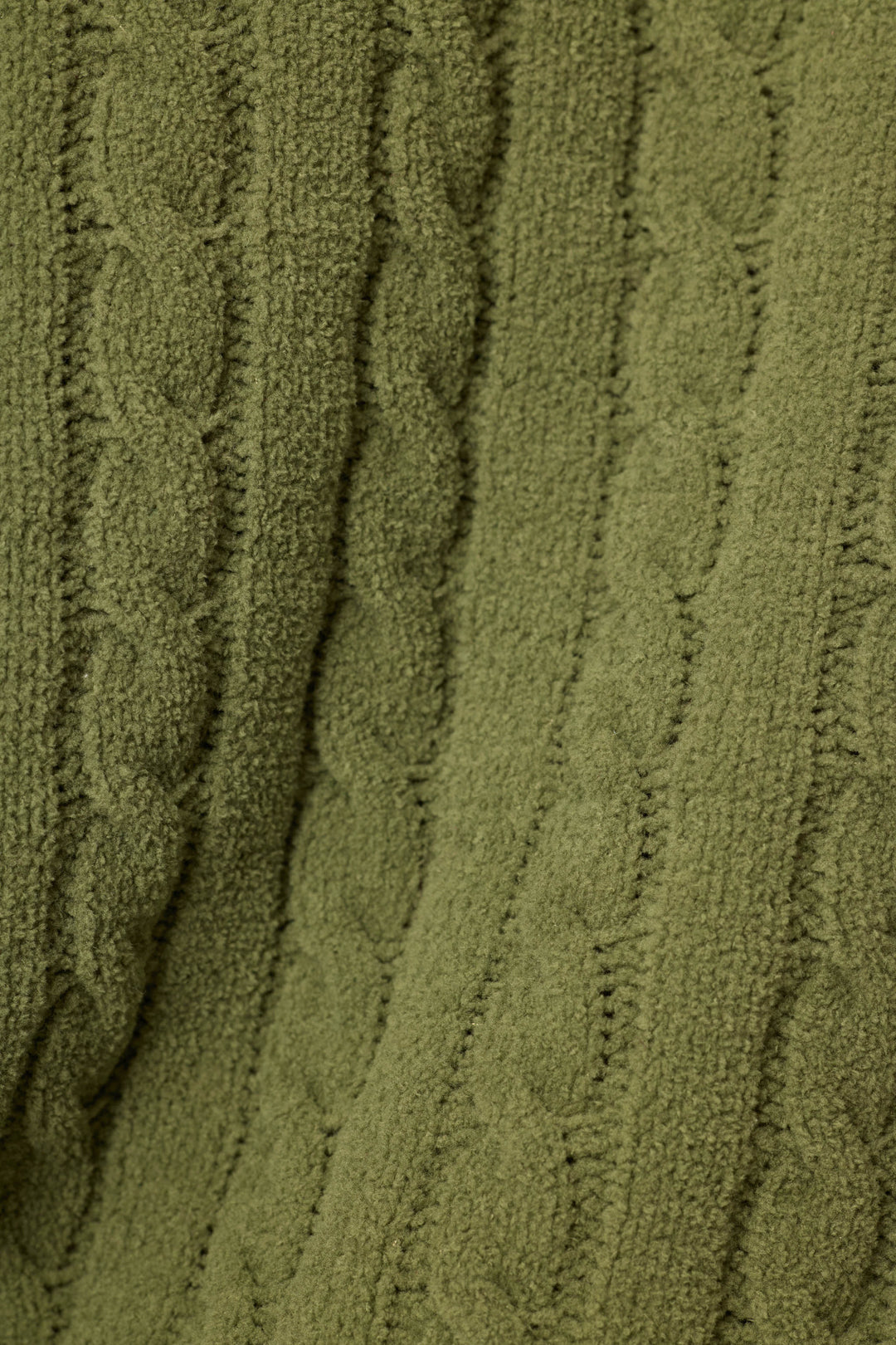 Close-up of a textured cable-knit fabric in an olive green color, showing the detailed knit pattern and ribbed vertical rows.