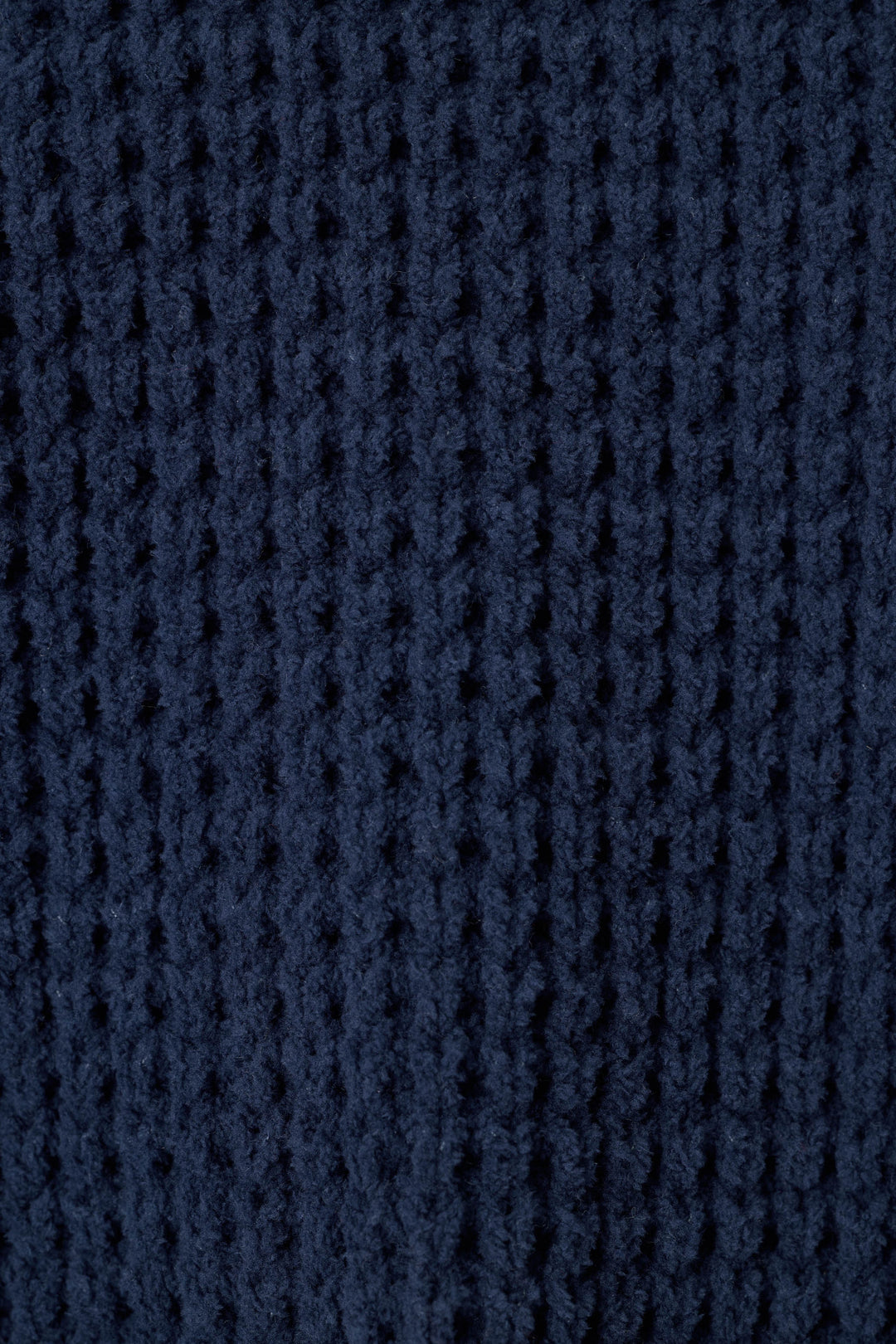 Close-up of a solid, dark navy blue waffle knit fabric texture.