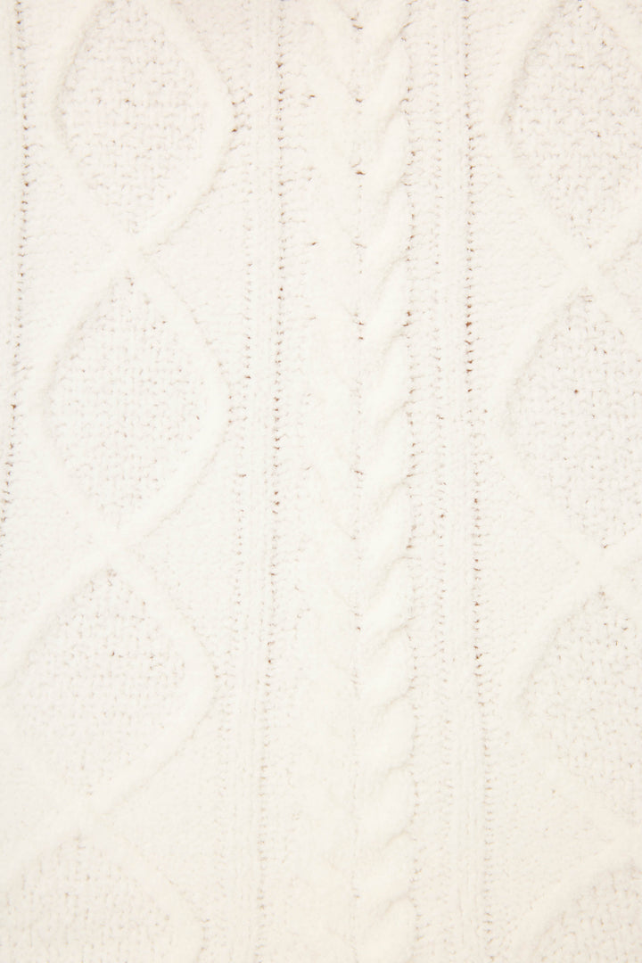 Close-up of white cable knit fabric with diamond and twisted rope patterns, evoking the cozy texture of P.J. Salvage Chenille Cable Knit Slippers, known for their plush fuzzy lining.