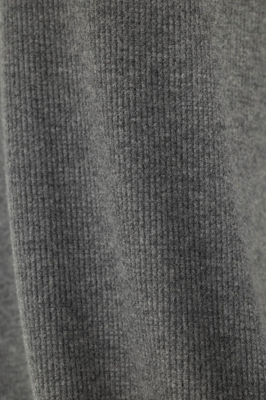 Close-up of a solid, dark gray waffle knit fabric texture.