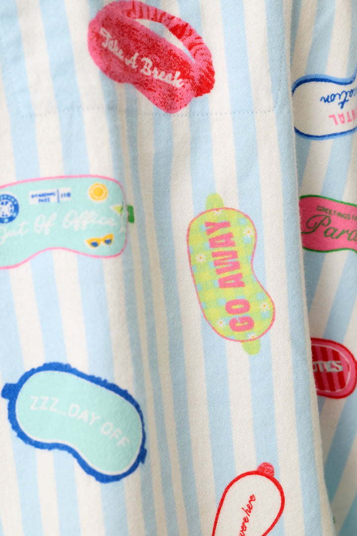 A close-up of a light blue and white striped fabric featuring colorful printed eye mask graphics with phrases like "Go Away", "Take A Break", "Out of Office", and many others.
