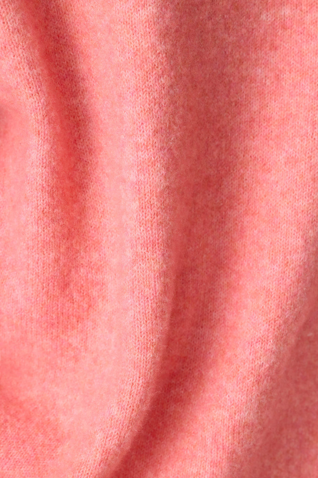 Close-up of the P.J. Salvage Mimosa Please Snuggle Sweater, featuring a soft, textured pink knit with gentle folds and a slightly fuzzy surface.