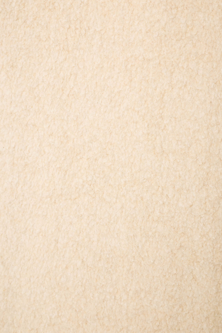 A close-up of soft, beige textured fabric with a plush, fleece-like look—perfect for the For the Mamas Sweetheart Banded Pants by P.J. Salvage.