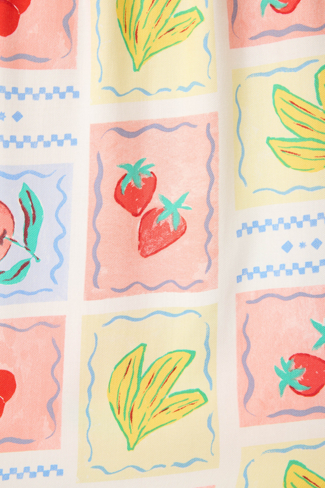 The Frutta Fresca Summer Harvest Camisole by P.J. Salvage features silky rayon sateen with a vibrant pattern of hand-drawn strawberries, bananas, and cherries plus blue borders—ideal for playful, fruit-print sleepwear.