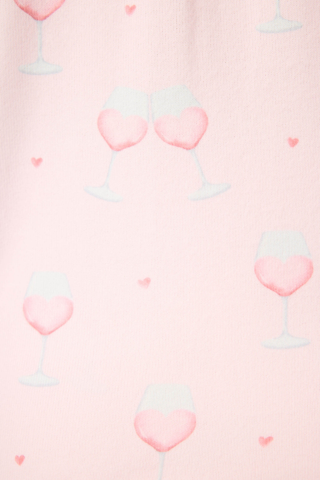 The P.J. Salvage Happy Hour Wine Glass Print 3-Piece Plus Size PJ Set features a light pink background with heart-shaped clusters of wine glasses filled with pink liquid, some clinking together, and scattered small pink hearts.