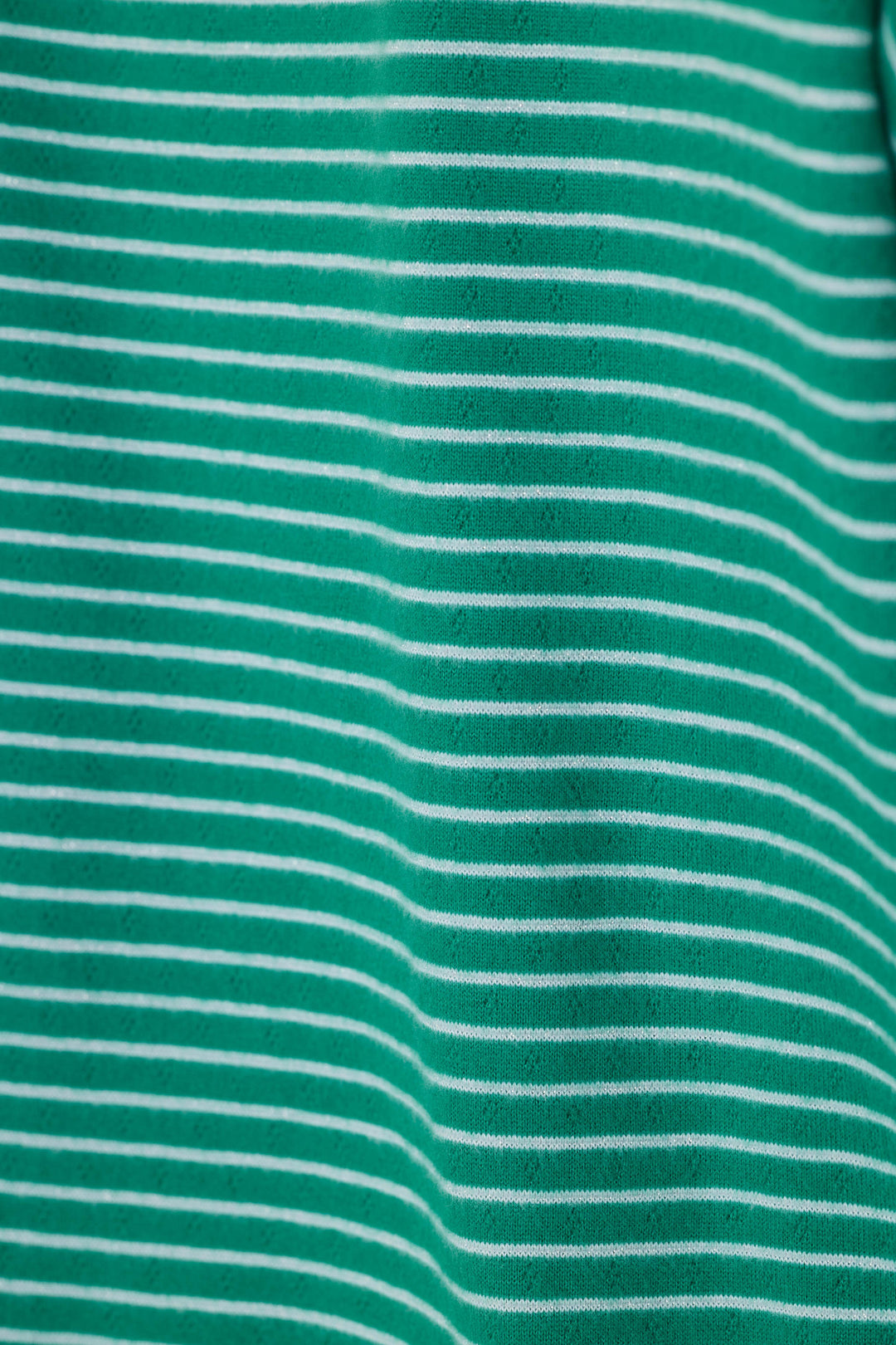 A close-up of a green fabric with thin, evenly spaced white horizontal stripes.