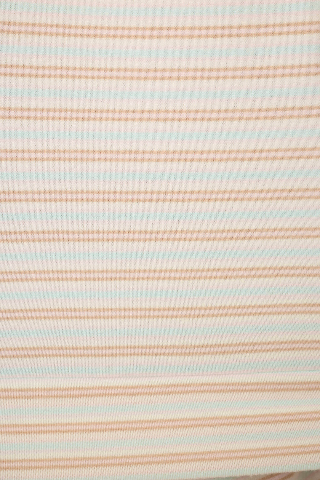 Close up of fabric featuring thin pink & blue stripes on a white background.