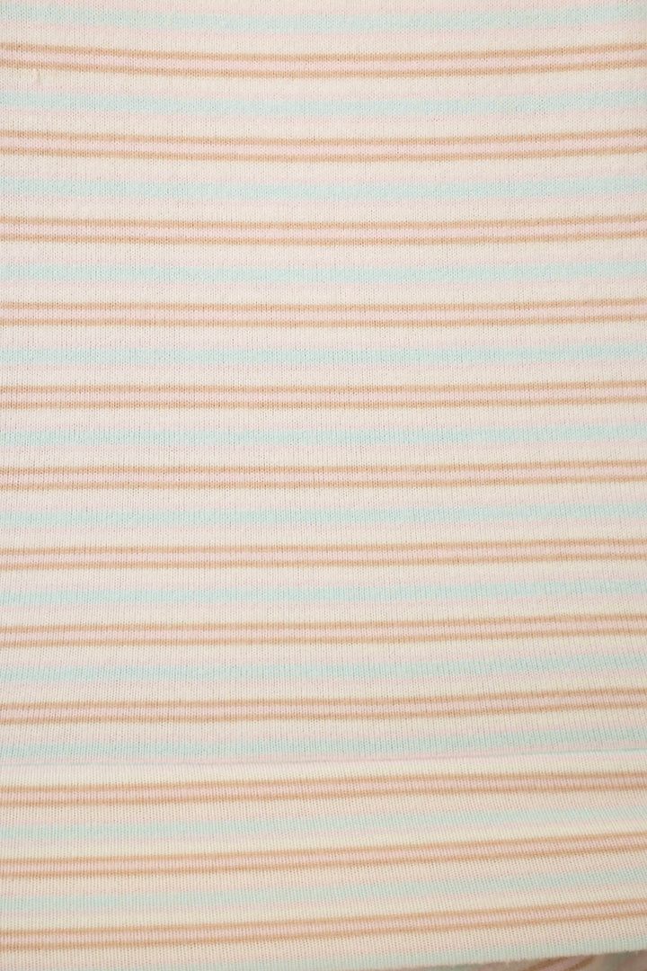 Close up of fabric featuring thin pink & blue stripes on a white background.