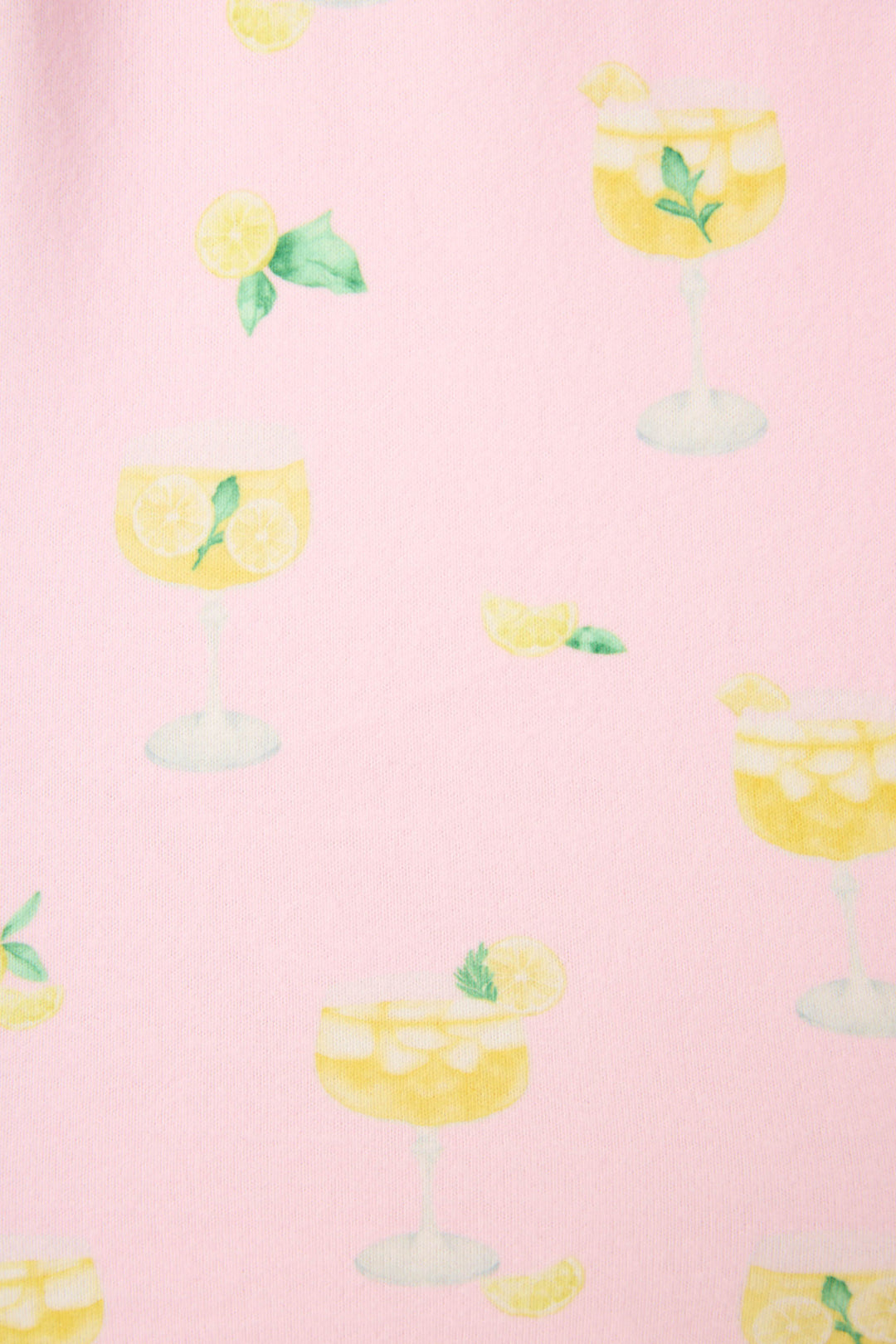Pattern of illustrated yellow drinks with lemon slices, mint leaves, and ice on light pink, with scattered lemon wedges and mint.