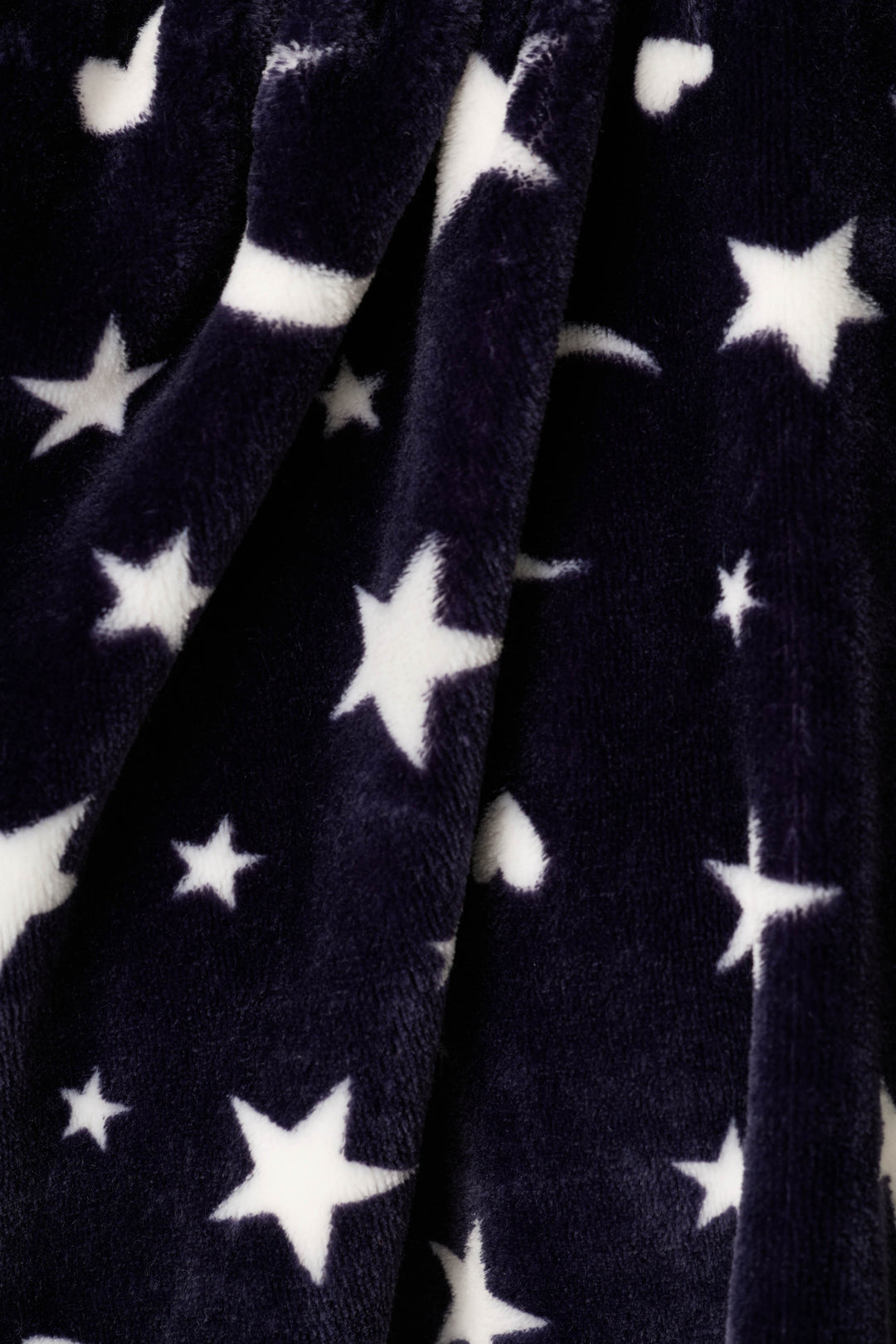 Close-up of a plush fabric with a white star & moon pattern on a dark navy background.