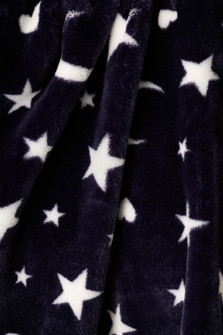 Close-up of a plush fabric with a white star & moon pattern on a dark navy background.