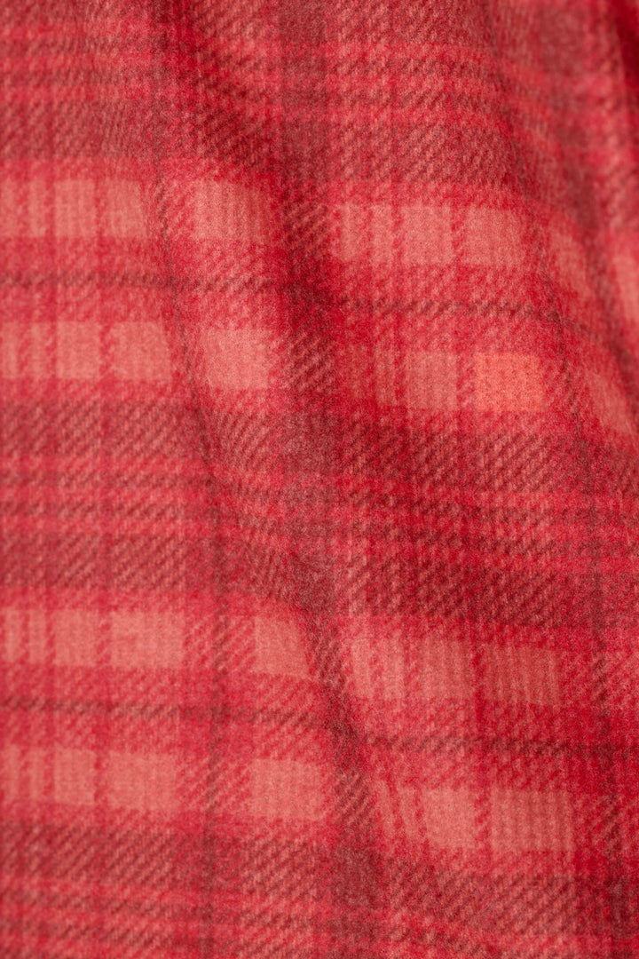 A close-up of a red plaid fabric texture with a soft, woven appearance.