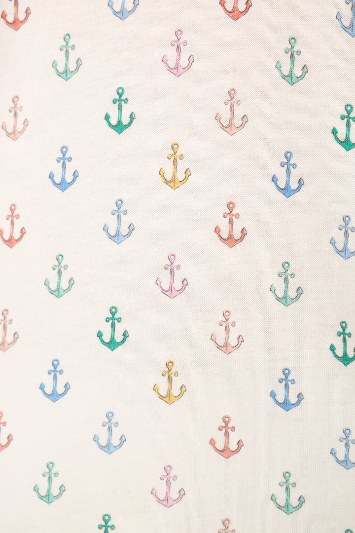 White fabric with evenly spaced rows of small red, green, yellow, blue, and purple anchors arranged in a grid pattern.