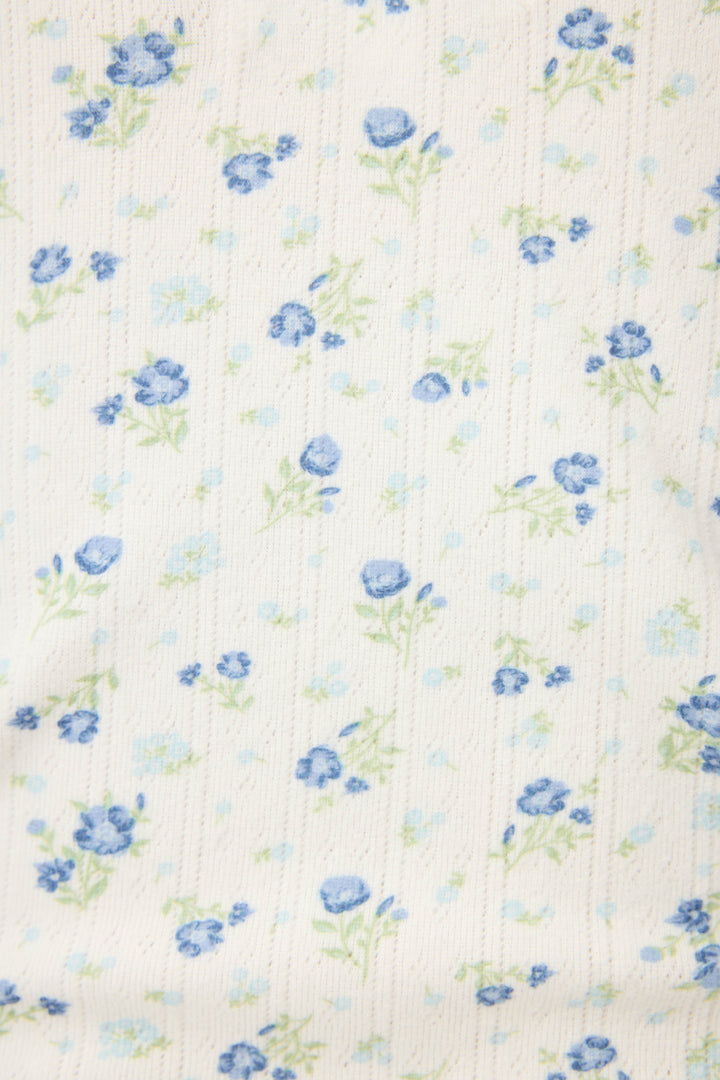 The P.J. Salvage More Amour Ditsy Floral Long Sleeve Pointelle Top features white ribbed fabric with a delicate scatter of small blue flowers and green stems, varying in size and density for a charming, textured look.