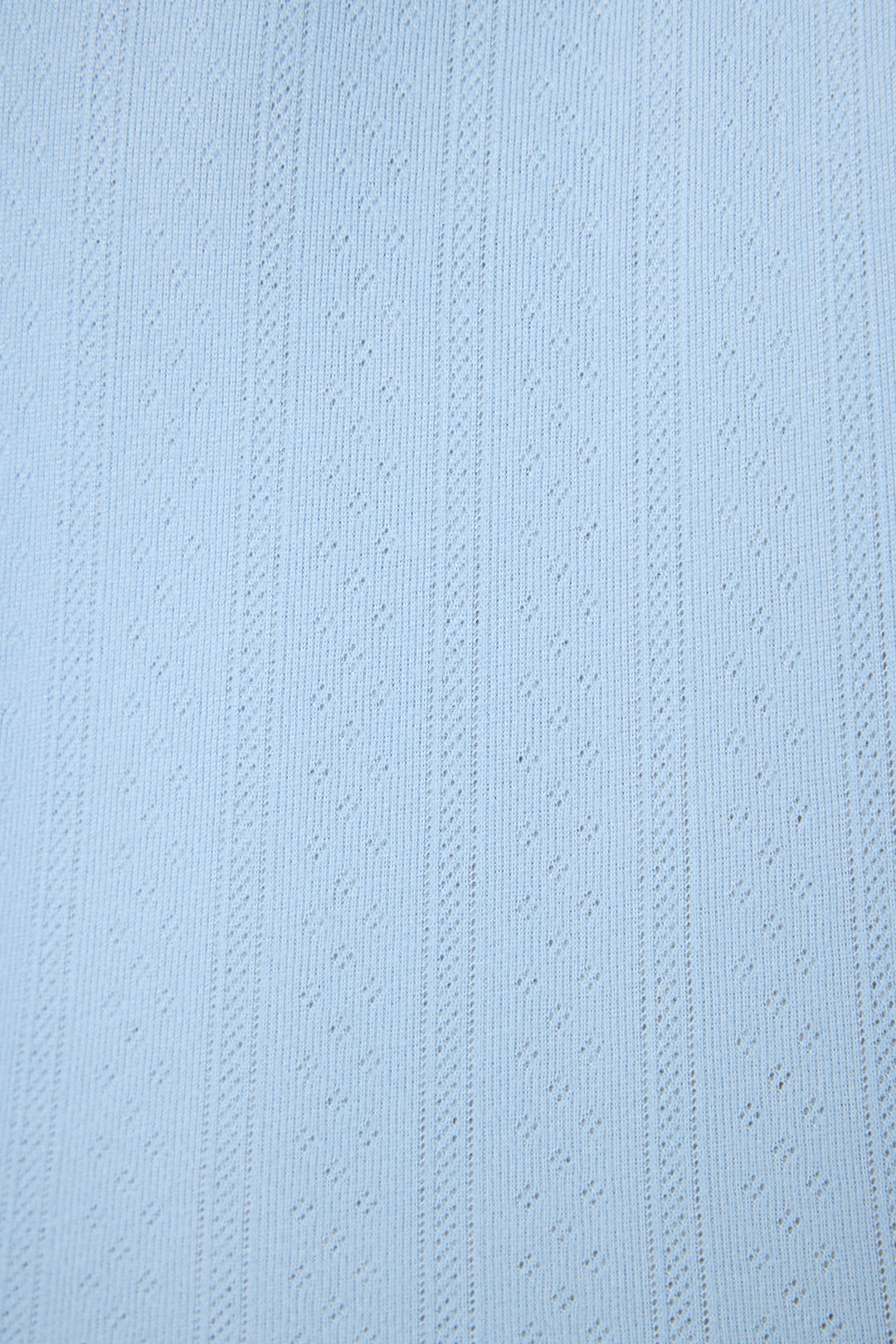 The P.J. Salvage More Amour Blue Dream Pointelle fabric features light blue fabric with a subtle textured pattern of vertical lines and evenly spaced small diamond shapes.