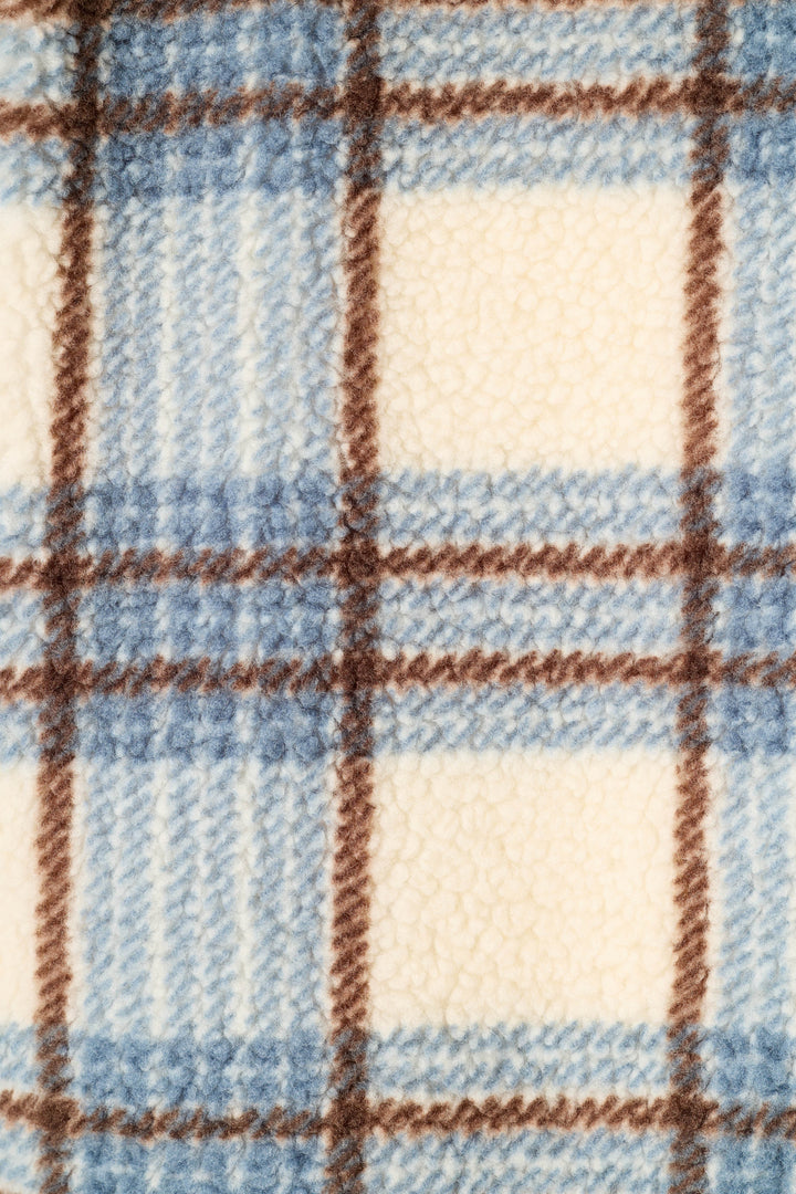 A close-up of a plush fleece fabric with a plaid pattern in light blue, cream, and brown.