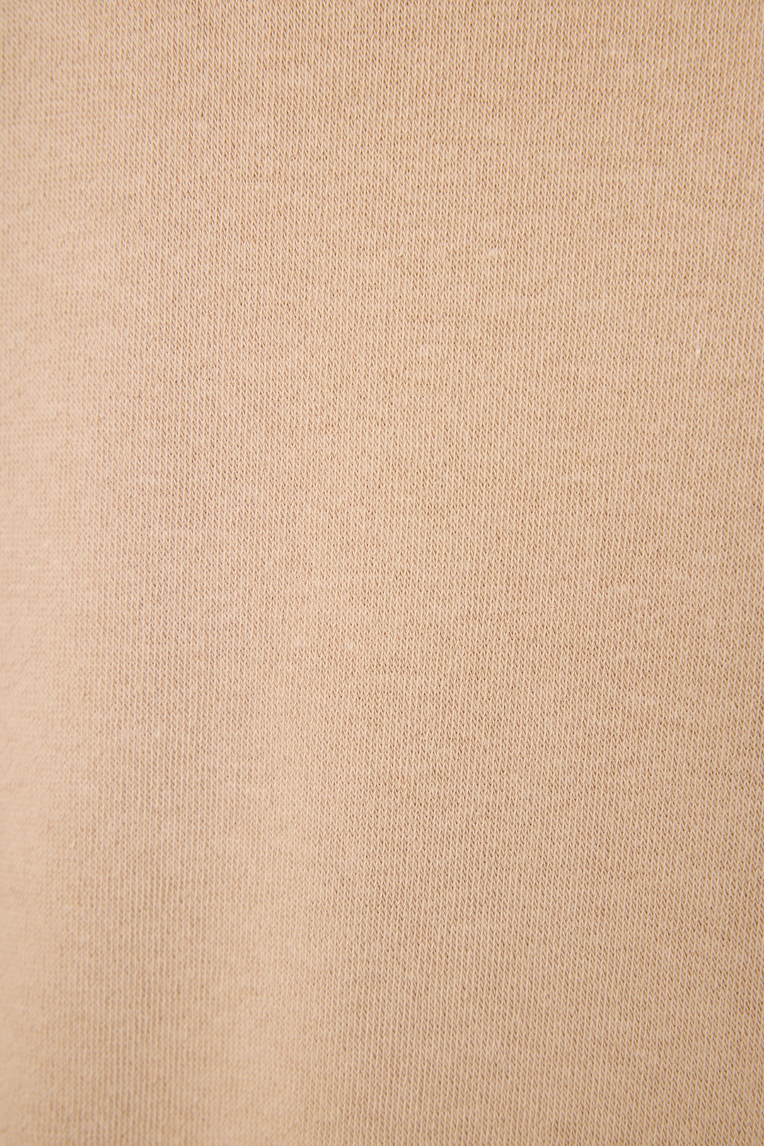 Close-up of the Palms Away Warm Taupe fabric featuring soft beige fabric with a fine, slightly ribbed knit texture and subtle diagonal lines for a cozy lounge look.