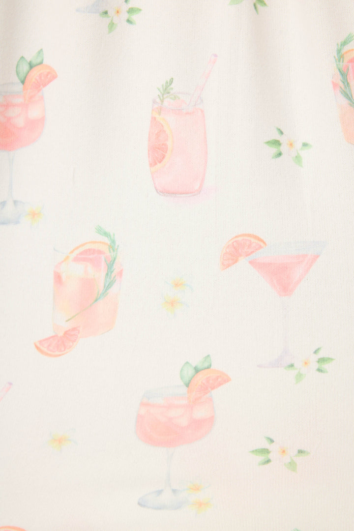 The Paloma Mama Sweet Sips Tank Top by P.J. Salvage features a breathable butter jersey ivory fabric with pink cocktail illustrations, citrus garnishes, herbs, and small white and yellow flowers—a fun sleepwear choice.