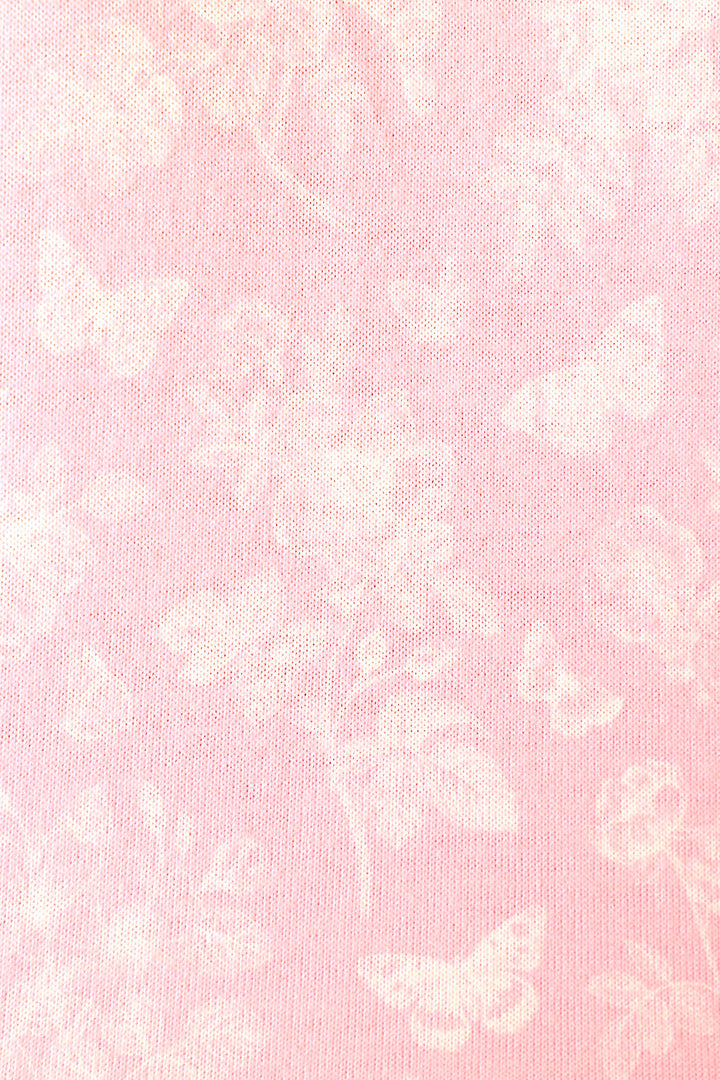 Soft baby pink fabric with white butterfly and floral patterns, creating a delicate, airy appearance.