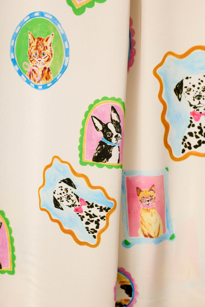 The Picture Purrfect Pet Portrait Print in a Sateen by P.J. Salvage is a cream-colored fabric adorned with playful, pastel portrait-style illustrations of cats and dogs—including Dalmatian and Boston Terrier breeds—set within colorful, framed designs.