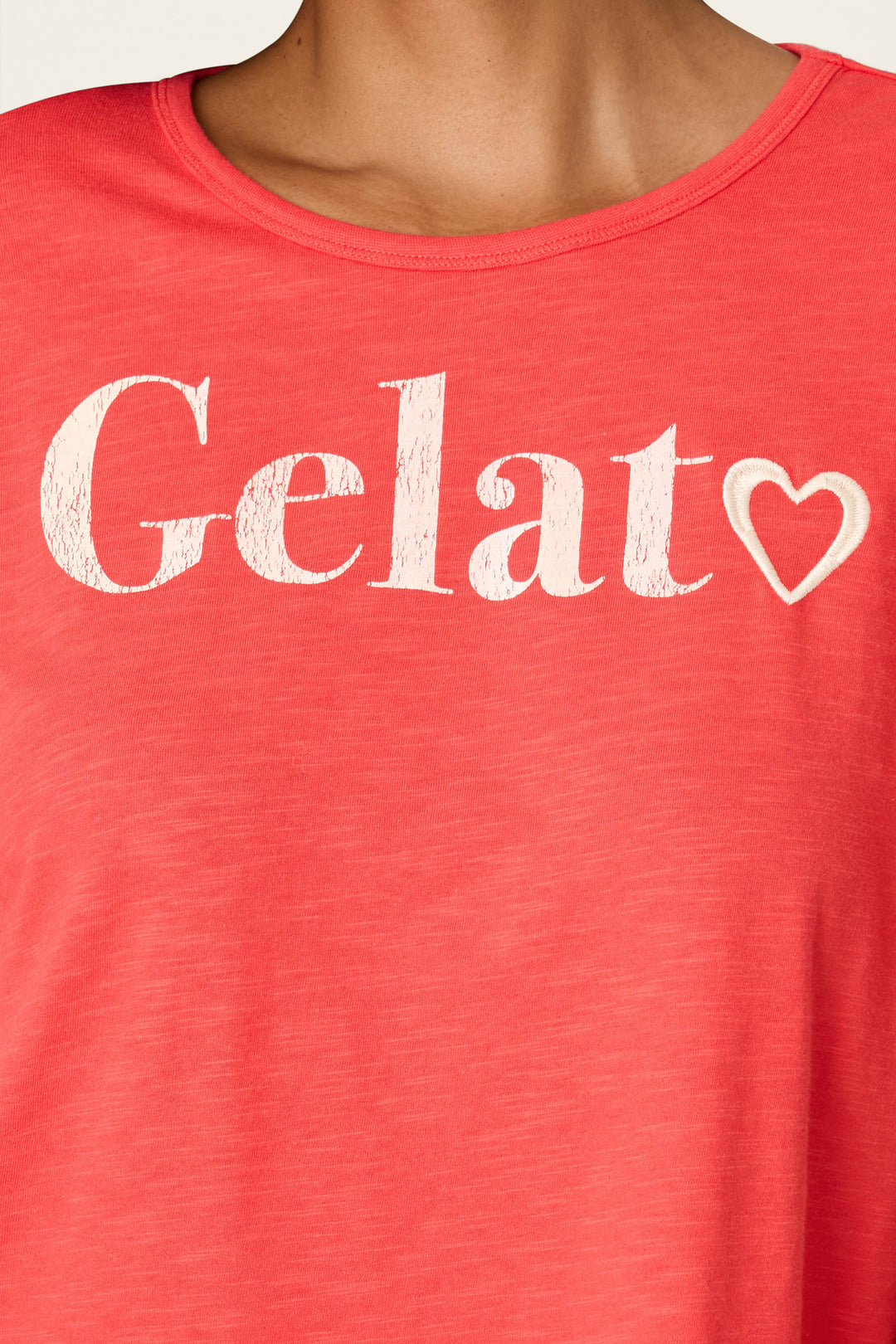 A person wearing P.J. Salvage’s Playful Prints Gelato Love Short PJ Set, featuring a pink top with “Gelat” and a white heart on the front—perfect for pairing with your favorite Gelato or Italian pajamas.