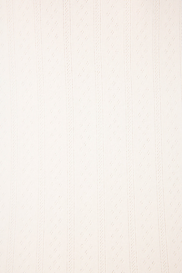 A close-up of the Pointelle Essentials Ivory Cardigan by P.J. Salvage shows its uniform, subtly raised vertical stripes and dotted texture in light beige fabric.