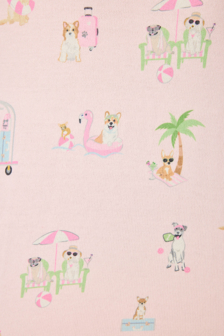 Dogs enjoy vacation moments—lounging, floating on a flamingo pool float, and playing under umbrellas—while sporting the P.J. Salvage Pupcation Palms Sunnies & Sunshine Banded Pants, all set against a light pink backdrop.