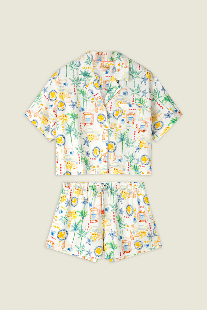 Colorful tropical print fabric featuring palm trees, stamps, and suns on a light background with a playful, vibrant look.