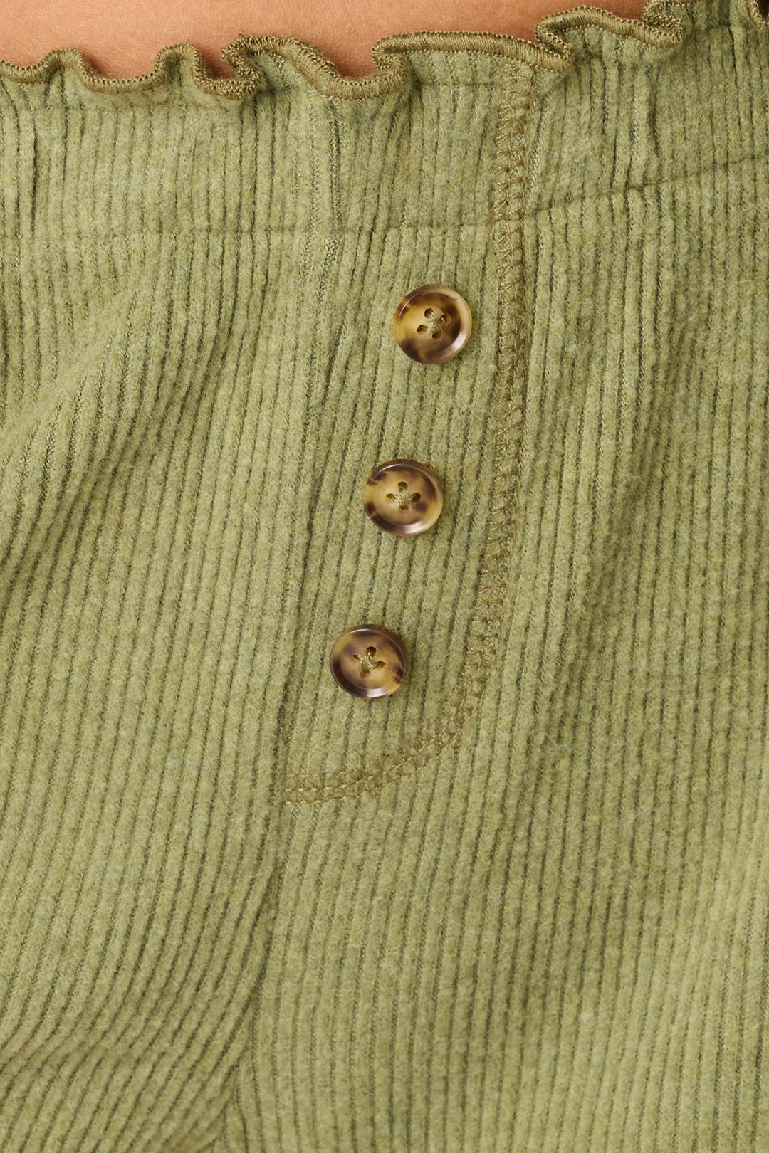 Close-up of the Olive You Forever Lounge Shorts by P.J. Salvage, featuring olive green corduroy fabric, three brown tortoiseshell buttons, and a ruffled waistband.