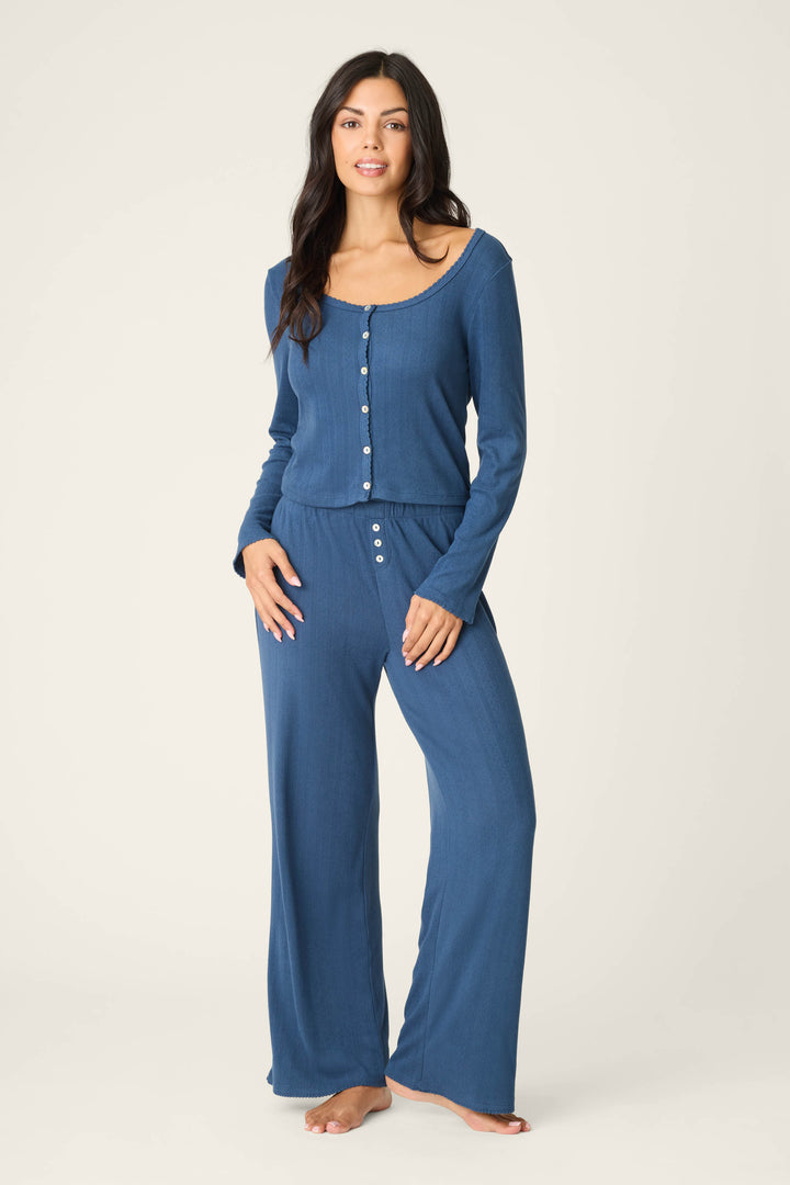 A person stands barefoot against a plain light background, wearing the P.J. Salvage Pointelle Essentials Deep Sea Cardigan as part of a cozy lounge set.